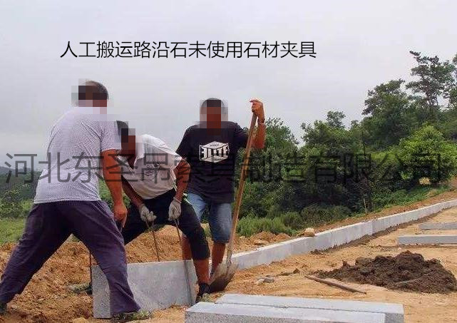 未使用雙人抬石頭的夾子作業(yè)現(xiàn)場，兩人使用鋼絲繩費力搬運路沿石--河北東圣吊索具制造有限公司--石材夾具|小型攪拌機|液壓堆高車|手動叉車